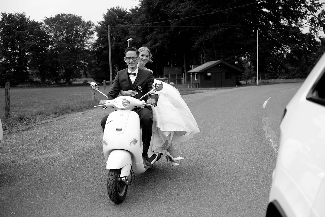 Glückliche Braut mit Bräutigam und Regenschirm